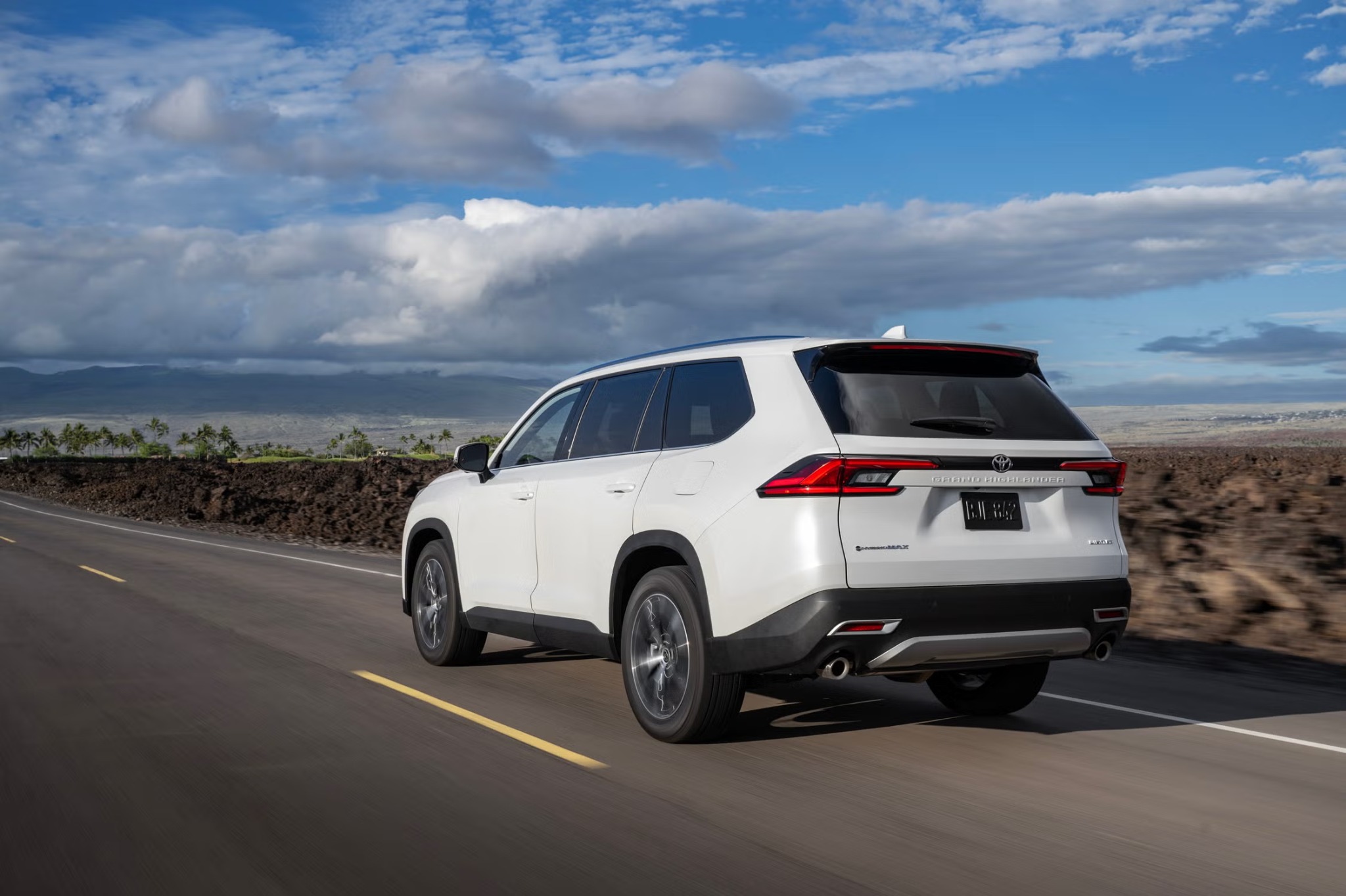Rear view of a white Toyota Grand Highlander on the road